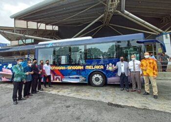 SULAIMAN Md. Ali (tiga dari kanan) bergambar di hadapan bas pelancongan elektrik Singgah-singgah yang disediakan secara percuma sehingga Mei ini. - UTUSAN/MUHAMMAD SHAHIZAM TAZALI