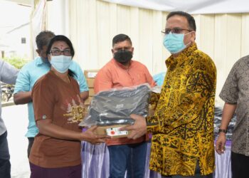 SA. Vigneswaran menyampaikan komputer riba kepada pelajar pada program Bantuan Tabung Pendidikan India Negeri Perak di Sungai Siput hari ini. - UTUSAN/ZULFACHRI ZULKIFLI