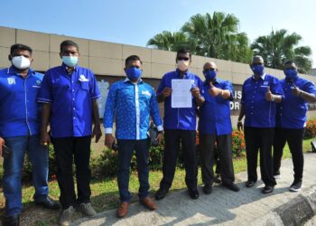 S. Supayyah (tengah) bersama ahli MIC menunjukkan laporan polis yang dibuat di IPD Kulai, Johor. - UTUSAN/RAJA JAAFAR ALI