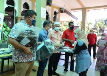 SYED Abdul Hafiz Syed Mustafa (dua dari kiri) menyampaikan sumbangan beg dan kelengkapan sekolah kepada pelajar sambil dibantu Syed Mohd. Johan Rizal Syed Unan Mashri (kanan) di Suka Menanti, Alor Setar hari ini. - UTUSAN/MOHD. RAFIE AZIMI