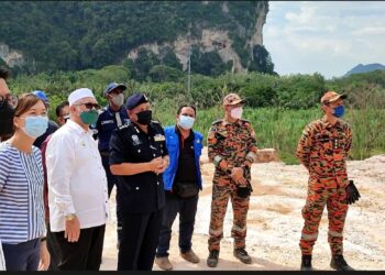 RAZMAN Zakaria (tiga dari kiri) meninjau kawasan runtuhan batu di tapak kuari di Keramat Pulai, Jalan Simpang Pulai-Cameron Highlands di Ipoh hari ini. - UTUSAN