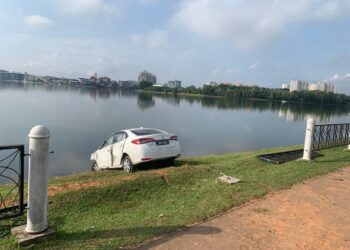 SEBUAH kereta hampir terjunam ke tasik apabila terbabas kerana mengelak anjing di Tasik Putrajaya. - IPD SEPANG