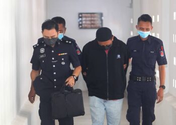 POLIS mengiringi Muhammad Nasution Noh (tengah) untuk didakwa di Mahkamah Sesyen Kota Bharu hari ini. - UTUSAN/ZULHANIFA SIDEK