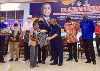 SAARANI Mohamad (tengah) menyampaikan beg sekolah kepada  penerima pada program CSR  bantuan persekolahan di Bota Kanan dekat Parit , hari ini. - UTUSAN/MOHAMAD HAFIZI MOHD SAID