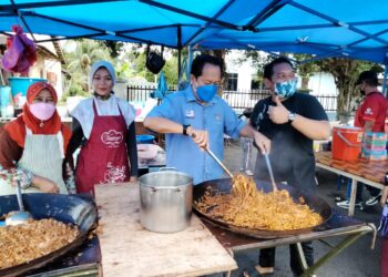 AHMAD Maslan menunjukkan kemahiran memasaknya ketika berkunjung ke Bazar Ramadan Pekan Ayer Baloi di Pontian, petang semalam. - UTUSAN/MUHAMMAD ZIKRI