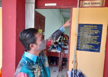 TAUFIK Abd. Rahman menunjukkan kesan retakan halus pada bangunan SK Simpang Ampat, Alor Gajah, Melaka. - UTUSAN/DIYANATUL ATIQAH ZAKARYA