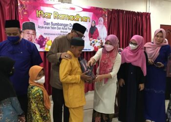 ZAHIDA Zarik Khan menyampaikan sumbangan duit raya kepada anak yatim di Dewan Merak, Kesedar Inn di sini, semalam. - UTUSAN/AIMUNI TUAN LAH