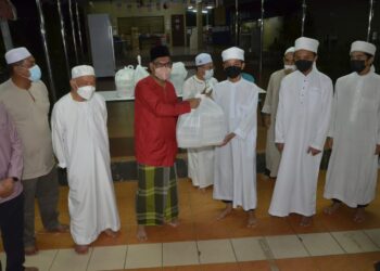 AHMAD Faizal Azumu (tiga dari kiri) menyampaikan pek makanan sahur kepada pelajar pada program singgah sahur di Maahad Tahfiz Al-Quran wal-Qiraat Addin 7 di Ipoh hari ini. - UTUSAN/ZULFACHRI ZULKIFLI