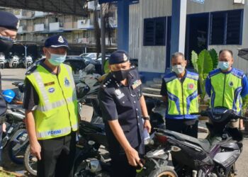 YAHAYA Hassan (tiga dari kiri) menunjukkan motosikal yang disita dalam Op Samseng Jalanan di Station 18, Ipoh hari ini. - UTUSAN