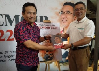 ADLY Zahari (kanan) menyerahkan Memoir 22.11 sebagai cenderahati kepada Sayed Munawar Sayed Mustar yang bertindak sebagai pengulas buku pada majlis pelancaran buku tersebut di Bandar Hilir, Melaka. - UTUSAN/MUHAMMAD SHAHIZAM TAZALI