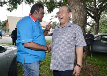 AMINUDDIN Harun berseloroh dengan M. Ravi ketika masing-masing yang merupakan lawan bagi merebut Ketua Cabang Port Dickson dalam Pemilihan PKR 2022 terserempak di tempat pengundian secara fizikal di Dewan Bandar Springhill, Port Dickson hari ini. - UTUSAN/MOHD. SHAHJEHAN MAAMIN