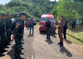 UMRANI  Che Mat  (kanan) memberi taklimat kepada anggota pasukan penyelamat dua pendaki dihanyutkan kepala air yang memasuki hari ketiga di Gunung Suku di Simpang Pulai hari ini.  - UTUSAN/MOHAMAD HAFIZI MOHD. SAID