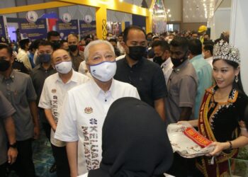 ISMAIL Sabri Yaakob diiringi oleh Hajiji Noor semasa melawat gerai pameran sempena Jelajah Aspirasi Keluarga Malaysia di Kota Kinabalu hari ini.