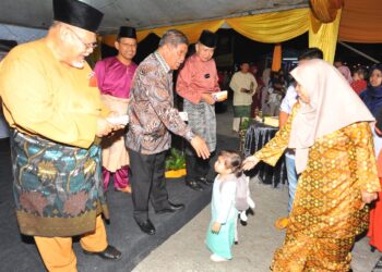 MOHAMAD Sabu menyampaikan duit raya kepada seorang kanak-kanak sambil diperhatikan Salahuddin Ayub dan Aminolhuda Hassan sempena Majlis Sambutan Hari Raya Aidilfitri Amanah Johor di Kempas, Johor Bahru di sini. UTUSAN/RAJA JAAFAR ALI