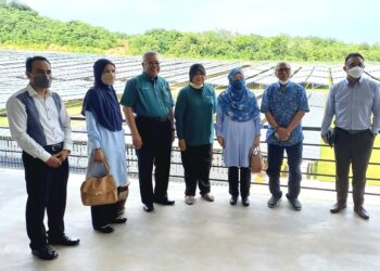 GUNTONG Tobeng (lima dari kanan) bergambar kenangan bersama Azizah Mohd. Dun (tiga dari kanan) berlatarbelakangkan panel solar di Kompleks Hijau, Ayer Keroh, Melaka. - UTUSAN/AMRAN MULUP