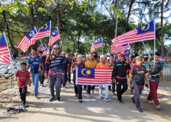 MOHD. Huzaimy Che Husin (depan, tiga dari kiri) turut menyertai perarakan Hari Kebangsaan Peringkat Parlimen Bachok bermula dari tapak pasar malam ke tapak ekspo di Pantai Irama, Bachok, Kelantan.UTUSAN/MUSTAQIM MOHAMED