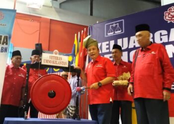 AHMAD Jazlan Yaakob (dua kanan) memalu gong sebagai gimik perasmian Majlis Pelancaran Jentera PRU 15 Veteran UMNO Negeri Kelantan dan Perasmian Keluargaku Pengundi BN di Lubok Jong, Rantau Panjang, Kelantan hari ini.UTUSAN/ROHANA ISMAIL.