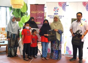 ASMA Ahmad (dua dari  kanan) menyampaikan sumbangan kepada Noradilah Rani dan empat orang anaknya dalam program penyerahan sumbangan ISMA kepada anak-anak yatim Covid-19 di pusat beli-belah Aeon Bandar Dato' Onn, Johor Bahru.