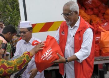 MAHFUZ Omar menyampaikan sumbangan kepada penerima pada majlis di Kampung Aman, Pokok Sena hari ini.