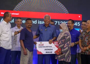 MAHDZIR Khalid (tengah) menyampaikan hadiah cabutan bertuah kepada pengunjung selepas merasmikan Mini KUD Padang Terap di Kuala Nerang hari ini - UTUSAN/ SHAHIR NOORDIN