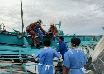 ANGGOTA bomba mengeluarkan mangsa yang tersepit dalam kejadian kren runtuh di sebuah kilang di Kampung Acheh, Sitiawan. - UTUSAN