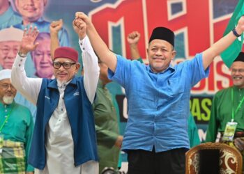 ABDUL Hadi Awang mengangkat tangan Shahidan Kassim selepas diumumkan sebagai calon Parlimen Arau atas tiket PN di Rusila, Marang, Terengganu, malam ini. - UTUSAN/PUQTRA HAIRYY ROSLI