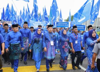 CALON BN Parlimen Machang, Ahmad Jazlan Yaakub (depan empat kiri) tiba di pusat penamaan calon diiringi bersama penyokong untuk ke Bilik Gerakan Pejabat Tanah Dan Jajahan Machang, Kelantan hari ini. - UTUSAN/KAMARUL BISMI KAMARUZAMAN