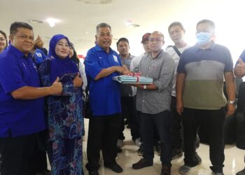 AHMAD Said (tengah) menerima borang menyertai UMNO daripada Laidin Rahim di Kemaman, hari ini. - UTUSAN/NIK NUR IZZATUL HAZWANI NIK ADNAN