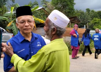 ZULKARNAIN Yusoff (kiri)  bersalaman dengan pengundi ketika berkempen di Kampung Tersang, Rantau Panjang, Kelantan hari ini.-UTUSAN/ROHANA ISMAIL