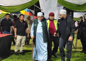 ABDUL Hadi Awang (tiga dari kanan) ketika tiba di tapak Ceramah Umum Pas di Padang Puteri Saadong, Wakaf Bharu, Tumpat malam tadi.  - UTUSAN/MUSTAQIM MOHAMED