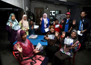 ROZIEANA Ahmad (empat dari kiri) bersama pengundi di Bilik Gerakan Kampung Belukar, Guar Sanji, Arau, Perlis malam tadi.- UTUSAN/IZLIZAN OTHMAN