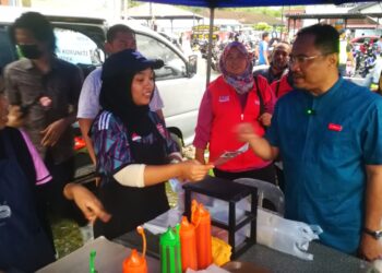 AZLI Yusof (kanan) menyampaikan risalah PRU15 kepada seorang peniaga di tapak pasar malam Kampung Padang Jawa hari ini.
ABDUL RAZAK IDRIS