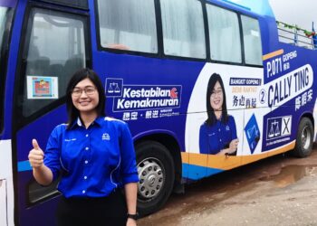 CALLY Ting menunjukkan bas Hoho yang disewa untuk kempen calon BN di Parlimen Gopeng di Gopeng semalam.  - UTUSAN/LIYANA RAMLI