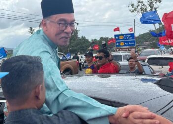 ANWAR Ibrahim (kiri) beramah mesra bersama orang ramai selepas menghadiri Kenduri Rakyat PH di Kampung Mengkuang Layar, Arau, Perlis, hari ini. -UTUSAN/ASYRAF MUHAMMAD