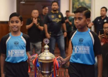 DUA pemain bola sepak kanak-kanak membawa piala pusingan Governor Cup 2022 ketika Majlis Pelancaran dan Undian Rasmi di MITC, Ayer Keroh, Melaka.