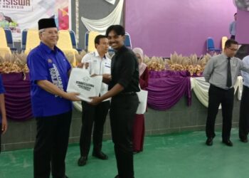 ANNUAR Musa (dua dari kiri) menyampaikan tablet PerantiSiswa kepada pelajar di SMTAR di Selekoh, Bagan Datuk, hari ini. - UTUSAN/SHAMSUL KAMAL AMARUDIN