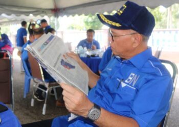 WAN ROSDY Wan Ismail membaca analisis dalam Utusan Malaysia bertajuk BN diramal miliki Pahang pada majlis ramah mesra bersama penduduk di Dewan Orang Ramai Chenor Seberang di Maran, Pahang. - UTUSAN/SALEHUDIN MAT RASAD