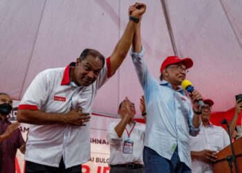 ANWAR Ibrahim mengangkat calon PH Parlimen Sungai Buloh, R. Ramanan pada sesi ceramah umum yang dijalankan di Sungai Buloh, Selangor, hari ini. -UTUSAN/HAFIZI MOHD. SAID