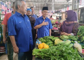 MOHD. Zubir Embong (tengah) dan Ahmad Said (kiri) beramah mesra dengan peniaga di Pasar Cabang Tiga, Kuala Terengganu hari ini. - UTUSAN/PUQTRA HAIRRY ROSLI