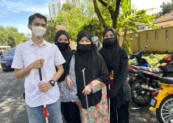 SITI Suhaila Mohd. Shafie (kanan) bersama ibu dan dua beradiknya yang menghidap masalah penglihatan keluar mengundi di SK Setapak Indah, Wangsa Maju.