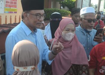 ANWAR Ibrahim bermesra dengan orang ramai selepas selesai mengundi di (SK) Seri Penanti, Permatang Pauh, Pulau Pinang pagi tadi.