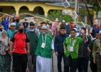 ABDUL Hadi Awang melambai tangan ketika hadir di pusat pengundian di SK Rusila, Marang. - UTUSAN/PUQTRA HAIRRY ROSLI