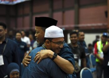 SHAHIDAN Kassim (kanan) dipeluk oleh Mohd. Ridzuan Hashim selepas meraikan kejayaan PN menyapu 14 daripada 15 kerusi DUN dan semua tiga Parlimen di Perlis. - UTUSAN/IZLIZAN OTHMAN