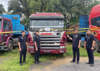 ANUWAL Ab Wahab (dua dari kanan) menunjukkan tiga buah lori yang turut dirampas susulan kes kehilangan rel kereta api yard Stesen Keretapi Gemas, Tampin baru-baru ini.-GAMBAR/IHSAN POLIS.