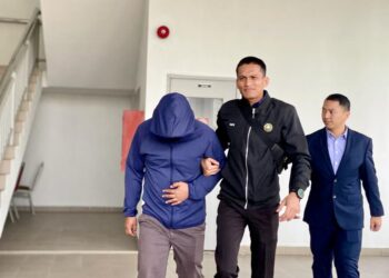 MUHAMAD Fitry Ismail (kiri) dibawa keluar dari kamar mahkamah selepas mengaku tidak bersalah terhadap pertuduhan menerima rasuah sebanyak RM1,500 di Mahkamah Sesyen Alor Setar. -UTUSAN/MOHD RAFIE AZIMI