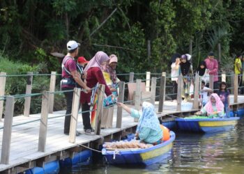 PENIAGA melayan pelanggan yang singgah di gerai mereka untuk membeli hidangan dijual di di Pasar Terapung Pulau Tengah, Kubang Kerian, Kelantan semalam.-UTUSAN/KAMARUL BISMI KAMARUZAMAN