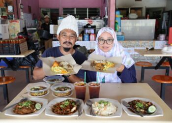 KAMARUZAMAN Hussin dan isterinya Siti Nor Farah Abdul Darawi menunjukkan pilihan Menu Rahmah yang ditawarkan kepada pelanggan di Restoran Pondok Kebaboom, Pasir Tumboh, Kota Bharu, Kelantan hari ini-UTUSAN/KAMARUL BISMI KAMARUZAMAN