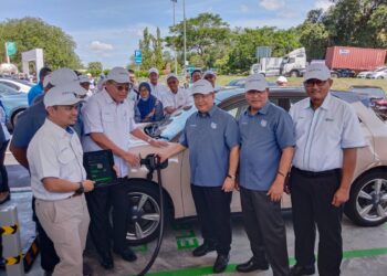 ALEXANDER Nanta Linggi (tiga dari kanan) mengecas kereta elektrik menggunakan TNB Electron di R&R Ayer Keroh arah Utara, Ayer Keroh, Melaka. - UTUSAN/MUHAMMAD SHAHIZAM TAZALI