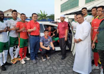WAN Roslan Wan Hamat (enam dari kanan) bersama pengurusan serta pemain-pemain Kelantan United FC ketika melancarkan kenderaan rasmi pasukan di Kota Bharu, Kelantan petang tadi.-UTUSAN/MUSTQIM MOHAMED