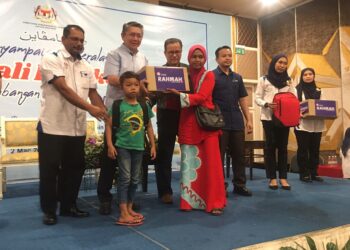 SALAHUDDIN Ayub (tengah) menyampaikan sumbangan kepada penerima pada Majlis Penyampaian Peralatan Kembali Ke Sekolah dan Sumbangan Bakul Rahmah di Kota Bharu, Kelantan hari ini. UTUSAN/ ROSMIZAN RESDI